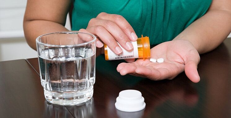 tomando comprimidos para aliviar a dor lombar